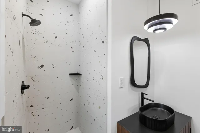 a bathroom with a granite countertop shower a sink and a toilet