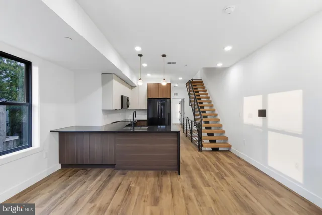 a view of a living room with furniture and wooden floor