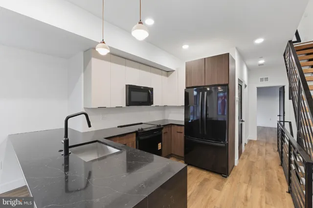 a kitchen with stainless steel appliances granite countertop a sink refrigerator and microwave