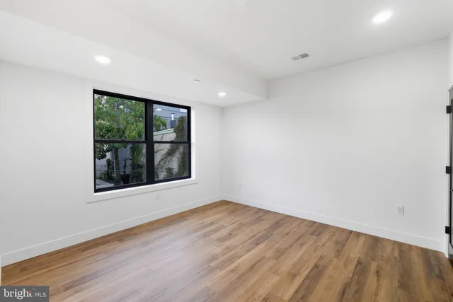 an empty room with wooden floor and a window