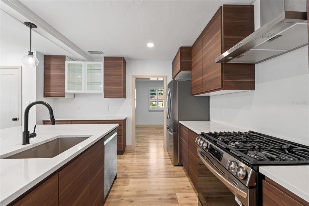 815 Northeast 12th Avenue Gainesville, FL 32601 - Photo 13 of 31 a kitchen with stainless steel appliances granite countertop a sink a stove and a wooden floors