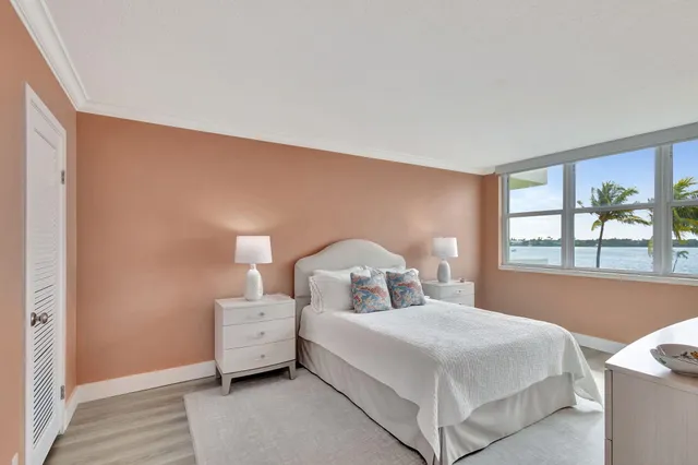 a bedroom with a bed and a large window