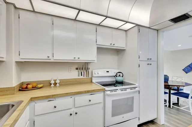 a kitchen with white cabinets and white appliances