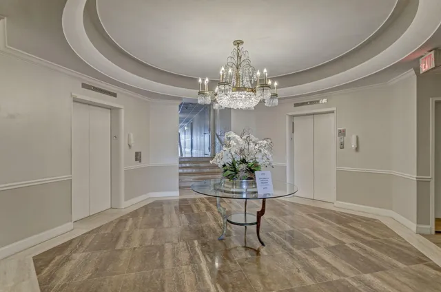 a dining room with chandelier and glass door