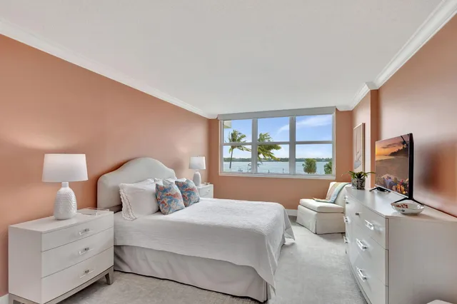 a bedroom with a bed and a flat tv screen on the dresser