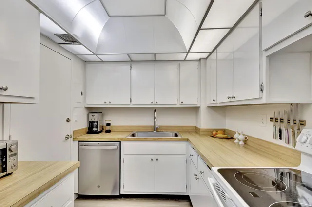 a kitchen with cabinets appliances a sink and a counter top space