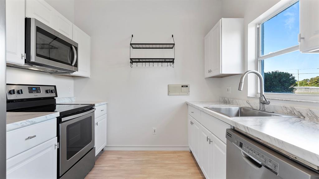 11029 Einbender Road Orlando, FL 32825 - Photo 5 of 27 a kitchen with stainless steel appliances granite countertop a sink stove and microwave