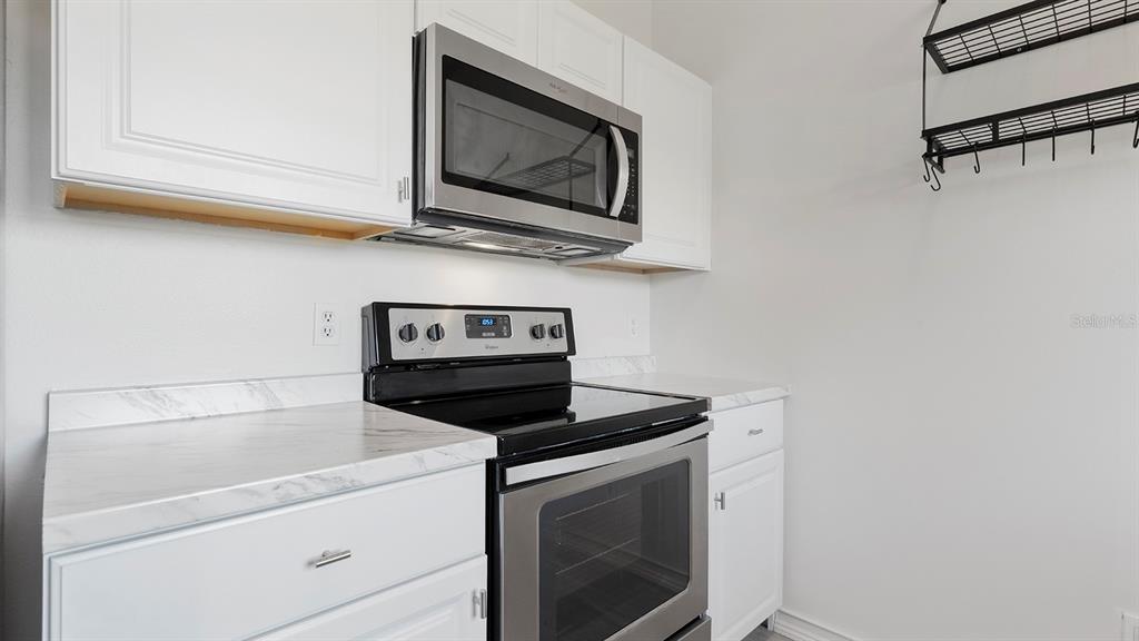 11029 Einbender Road Orlando, FL 32825 - Photo 7 of 27 a kitchen with microwave cabinets and stove top oven