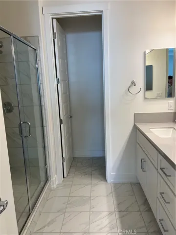 a bathroom with a granite countertop sink a mirror and a shower