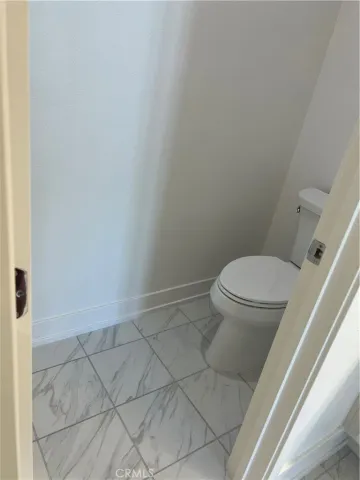 a white toilet sitting next to a shower
