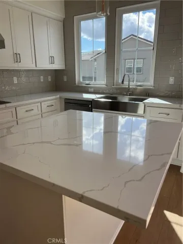 a kitchen with stainless steel appliances a sink a stove and white cabinets