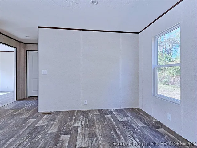 a view of a room with wooden floor and a window