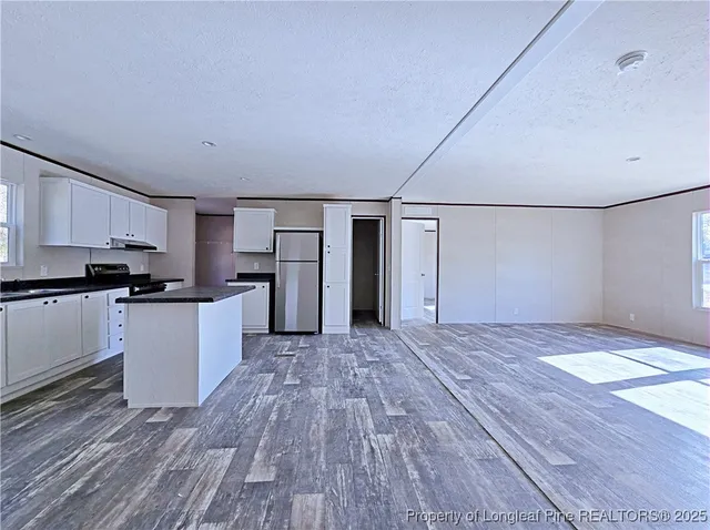 a view of kitchen with refrigerator microwave and stove top oven