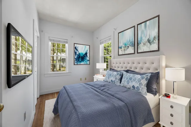 a bedroom with bed and window with wooden floor
