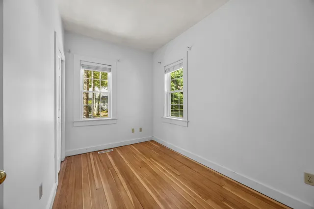 an empty room with window and closet area