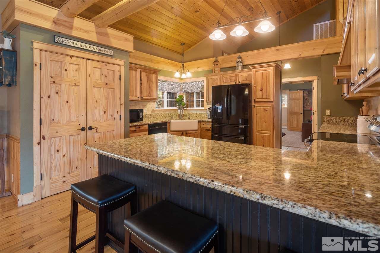 345 Prickly Pear Road Verdi, NV 89439 - Photo 8 of 26 a kitchen with stainless steel appliances granite countertop a table chairs and a refrigerator