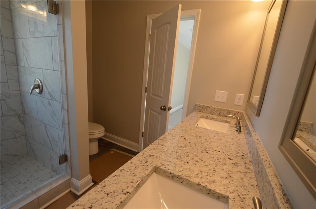 112 Jade Lane Dallas, GA 30132 - Photo 20 of 27 a bathroom with a granite countertop sink a toilet and shower