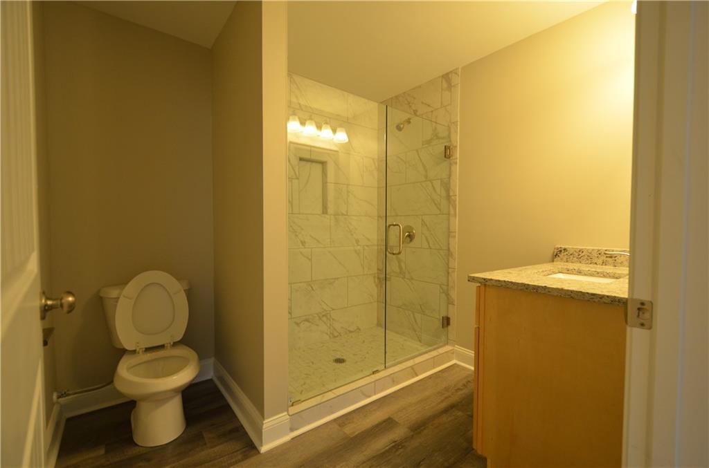 112 Jade Lane Dallas, GA 30132 - Photo 23 of 27 a bathroom with a granite countertop toilet and a shower