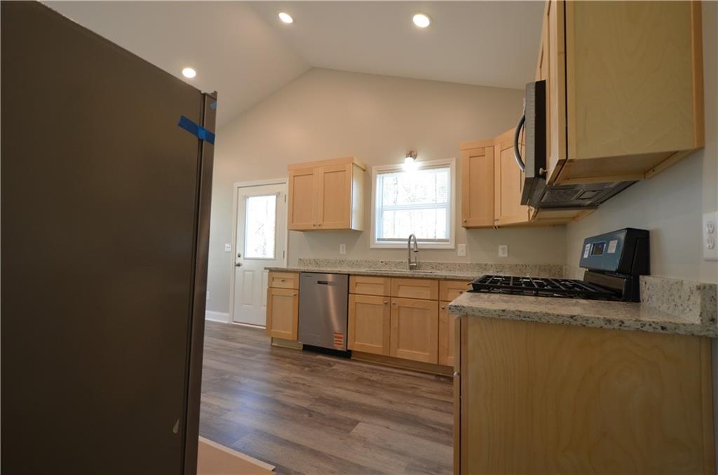 112 Jade Lane Dallas, GA 30132 - Photo 5 of 27 a kitchen with granite countertop a stove top oven a sink a counter space and cabinets