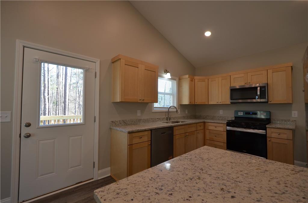 112 Jade Lane Dallas, GA 30132 - Photo 6 of 27 a kitchen with stainless steel appliances granite countertop a sink stove and refrigerator