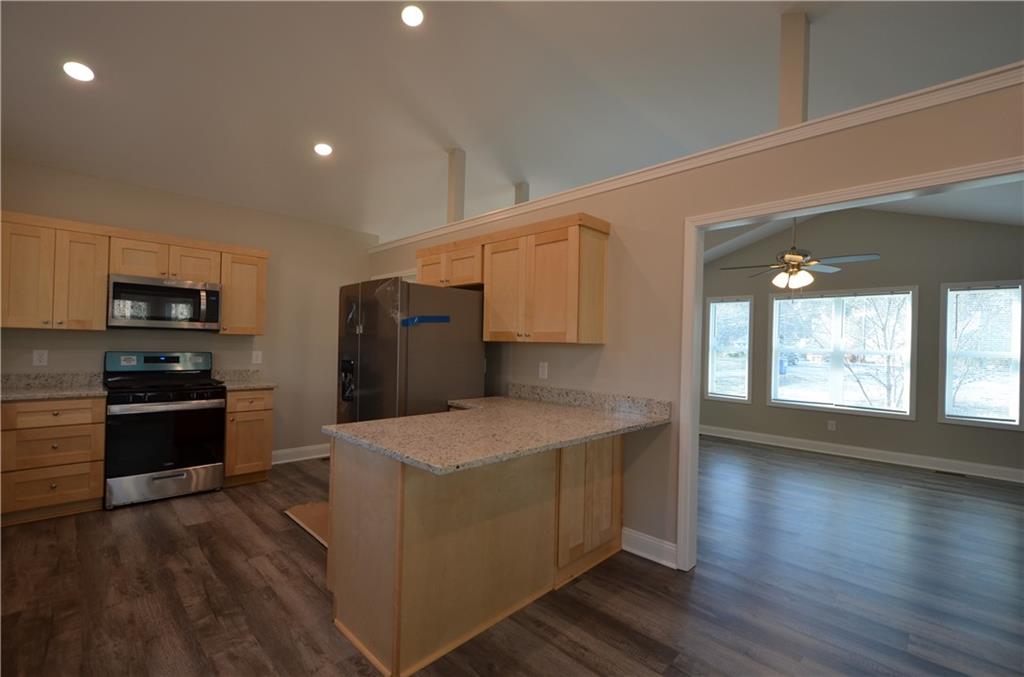 112 Jade Lane Dallas, GA 30132 - Photo 9 of 27 a kitchen with stainless steel appliances granite countertop a stove a refrigerator a sink a oven with wooden floor and cabinets