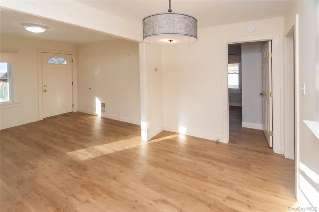 an empty room with wooden floor and bathroom