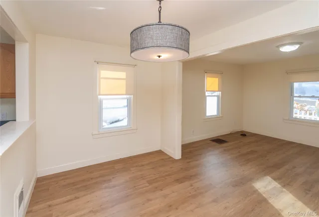 an empty room with windows and chandelier
