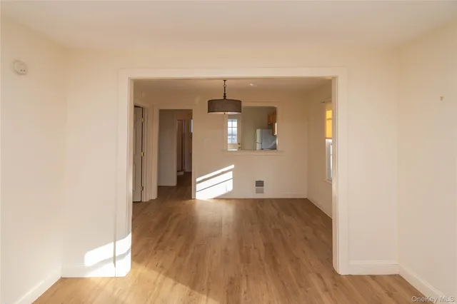 a view of a hallway with wooden floor and a living room