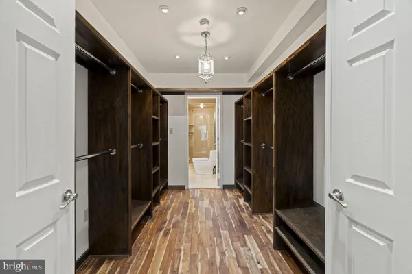 a spacious bedroom with a bed and wooden floor