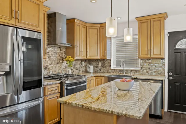 a kitchen with granite countertop a sink and stainless steel appliances