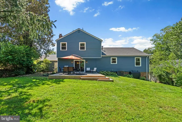 a patio with couches table and chairs under an umbrella