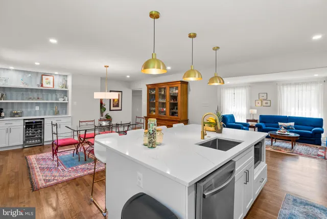 a kitchen with stainless steel appliances kitchen island granite countertop a refrigerator a stove top oven a sink dishwasher and wooden floor