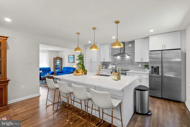 a living room with furniture a dining table and chairs with wooden floor
