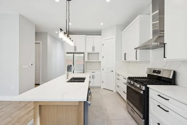 a kitchen with kitchen island a sink stainless steel appliances and cabinets