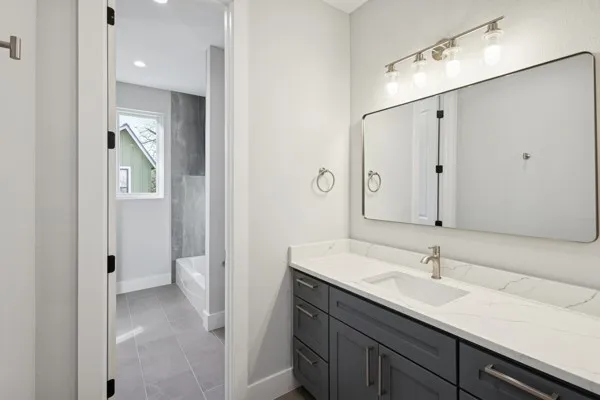 a en suite bathroom with a granite countertop sink and a mirror