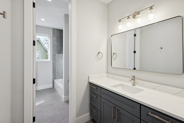 4801 Prock Lane, Unit A Austin, TX 78721 - Photo 17 of 24 a en suite bathroom with a granite countertop sink and a mirror