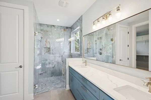 a spacious bathroom with a granite countertop sink mirror and shower