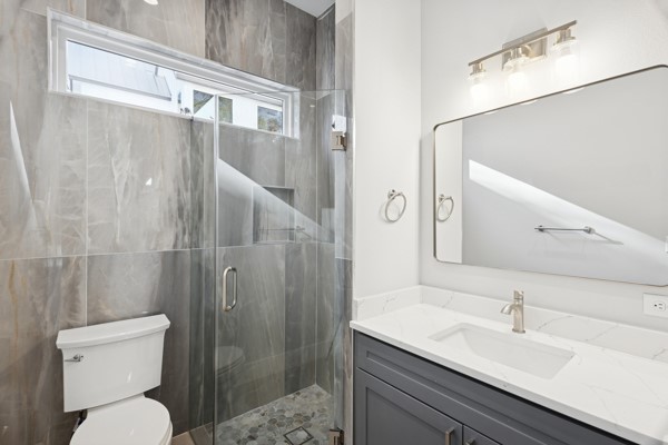 4801 Prock Lane, Unit A Austin, TX 78721 - Photo 5 of 24 a bathroom with a sink and mirror with toilet