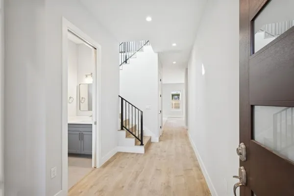 a view of a hallway with wooden floor and staircase