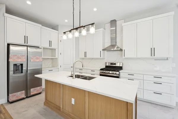 a kitchen with stainless steel appliances a stove a sink and a refrigerator