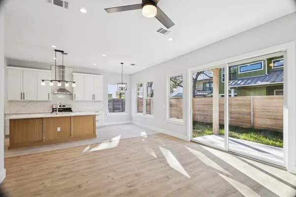 a large white kitchen with a stove a sink and a large window