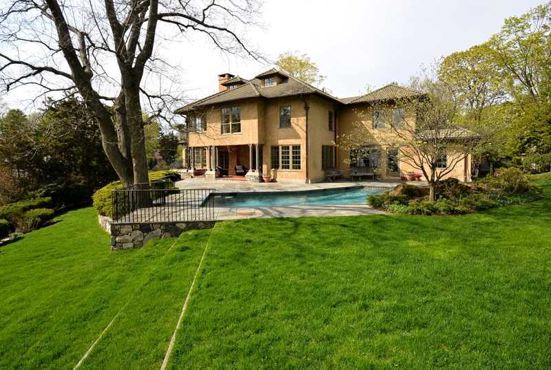 22 Searles Road Darien, CT 06820 - Photo 20 of 25 a front view of a house with a garden and trees