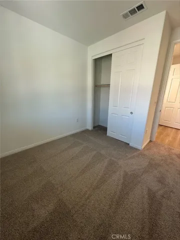 an empty room with closet and windows