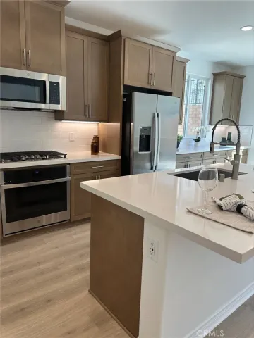 a kitchen with stainless steel appliances a stove microwave and refrigerator