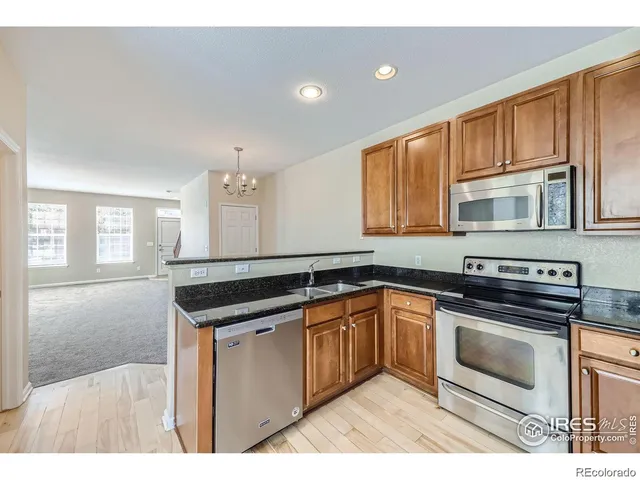a kitchen with granite countertop a sink stove and cabinets