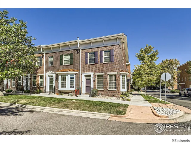 a view of a big building with a big yard and large trees