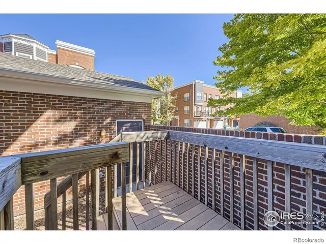 a view of a balcony with wooden floor and fence