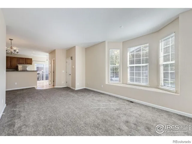 a view of an empty room with a kitchen