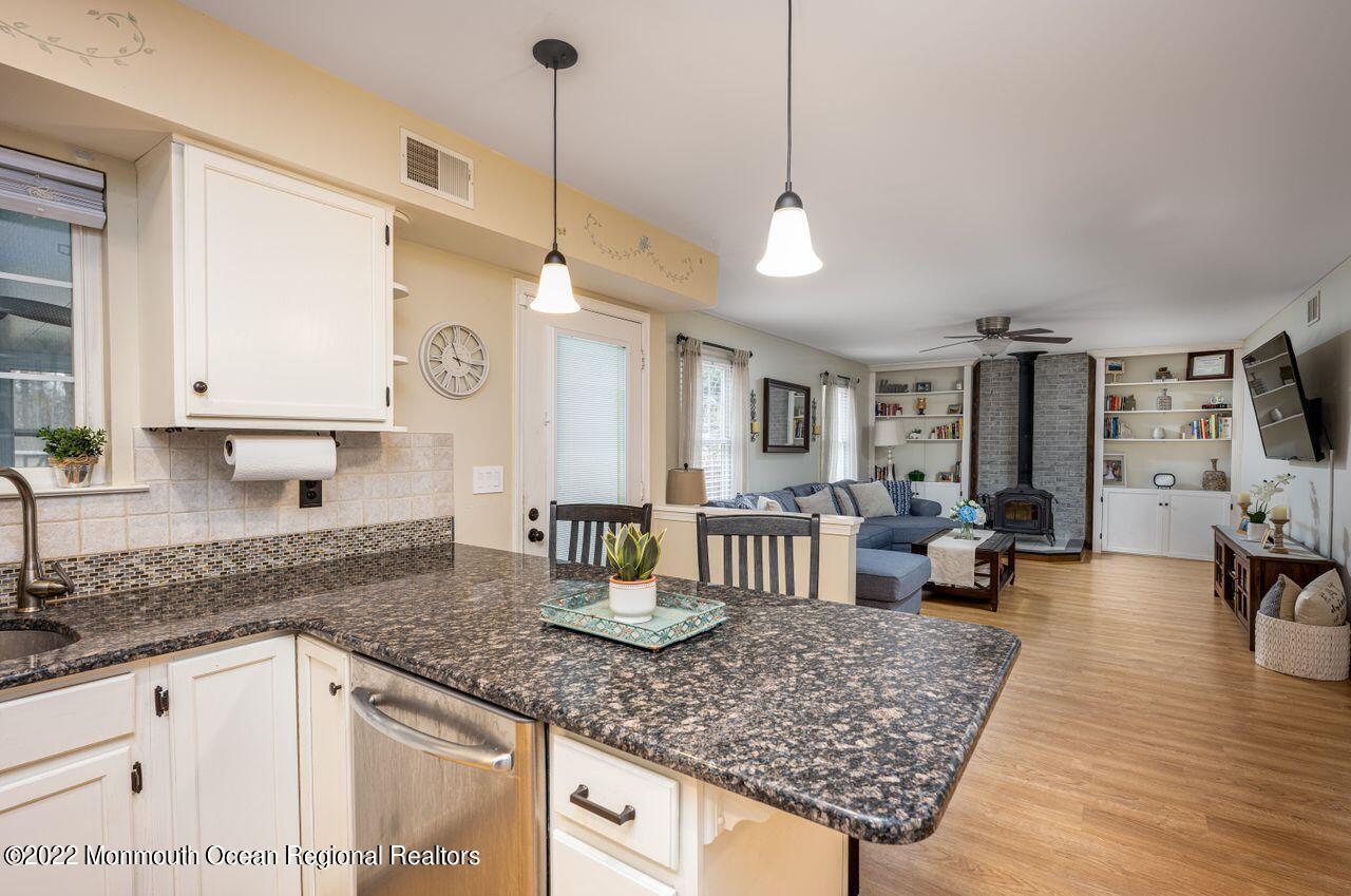 621 Reed Road Jackson, NJ 08527 - Photo 11 of 35 a kitchen with stainless steel appliances granite countertop a stove a sink and white cabinets with wooden floor