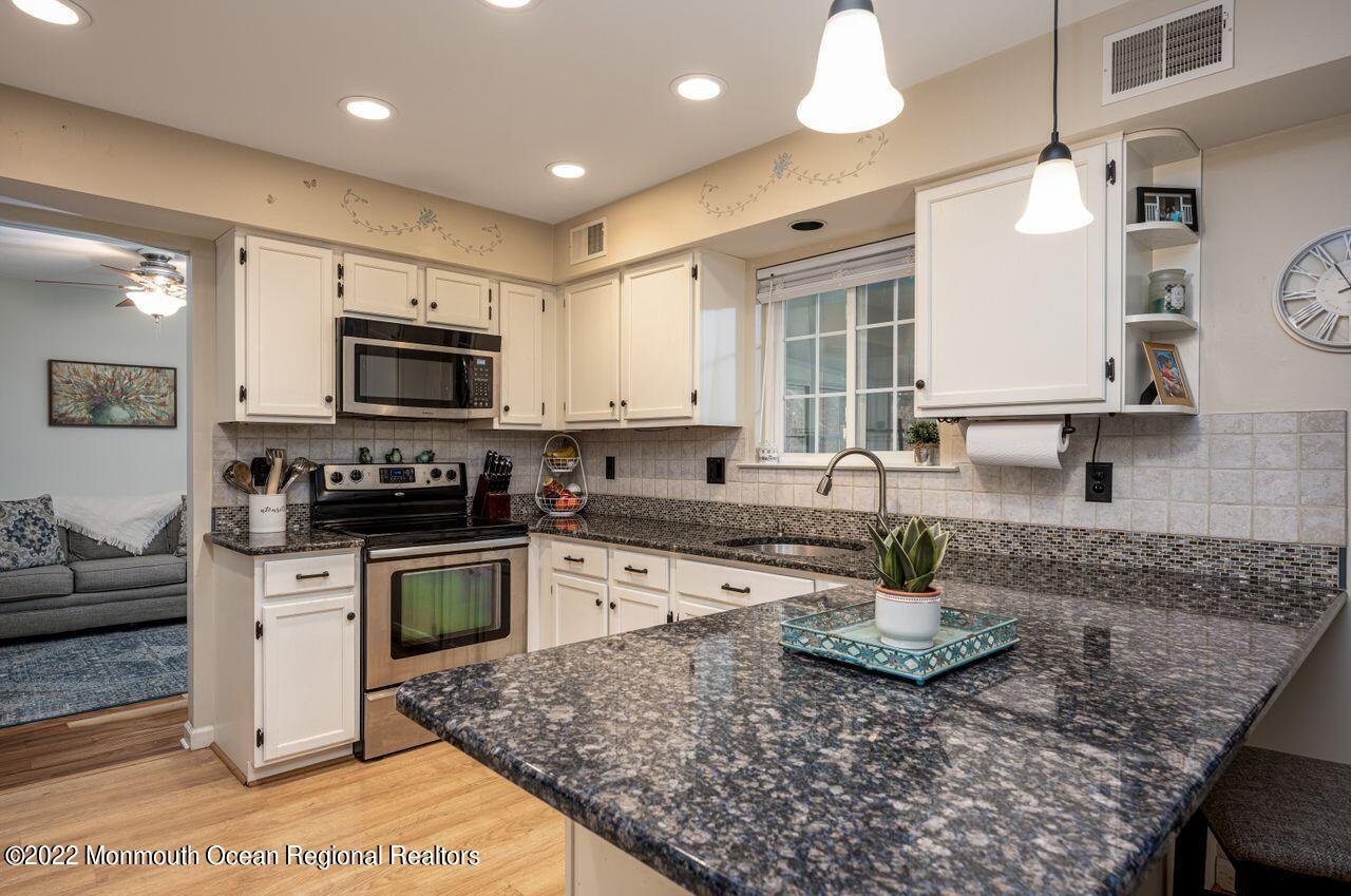621 Reed Road Jackson, NJ 08527 - Photo 8 of 35 a kitchen with stainless steel appliances granite countertop a sink stove and microwave